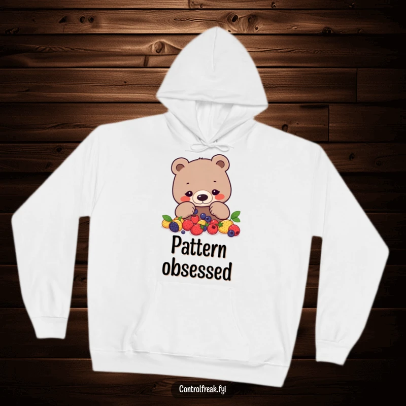 Funny bear hoodie with a focused bear arranging berries into a precise geometric pattern, perfect for cozy focus.